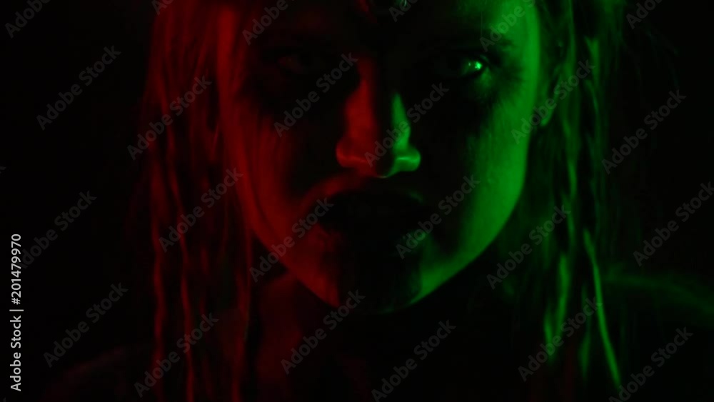 A woman with an unusual make-up moves smoothly in a nightclub at a party A woman with an unusual make-up moves smoothly in a nightclub at a party