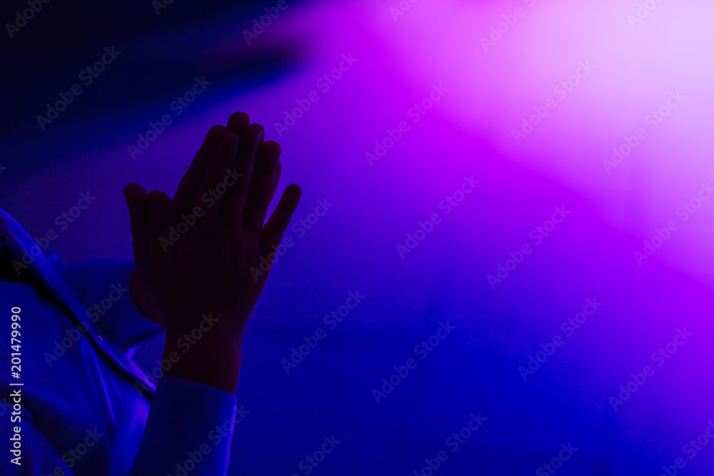 boy applauds in a room with blue and pink lighting