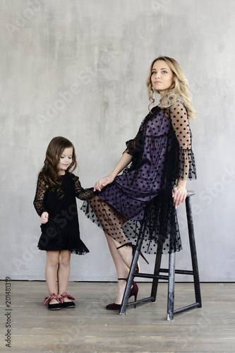 Fashion. Mom and daughter in the same black dresses