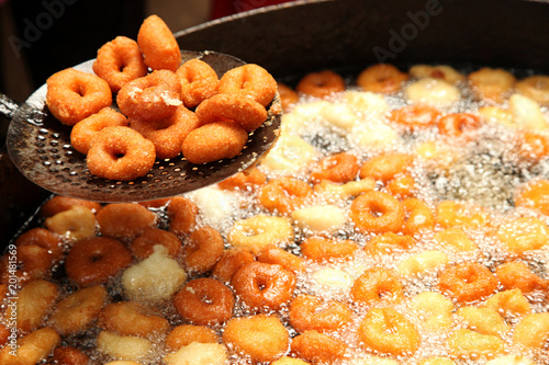 Deep frying medu vada in the pan. Medu Vada is a savoury snack from South India, very common street food in the India. photo