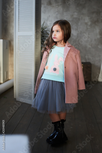 Children's lookbook. Stylish girl in pink coat