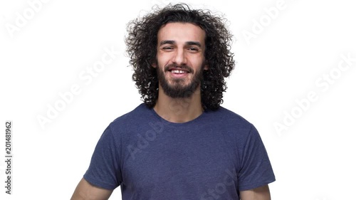 Portrait of attractive bearded guy in casual grinning and showing finger on camera meaning hey lucky you, isolated over white background. Concept of emotions