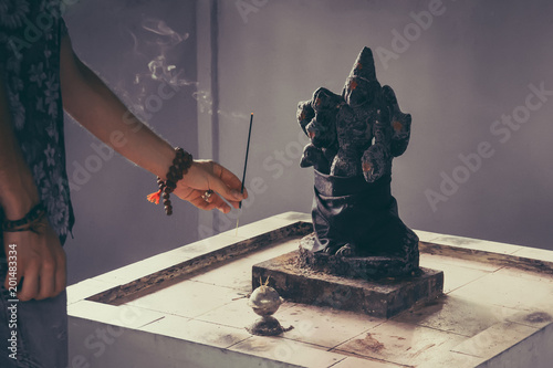 Hindu god Ganesh on black background. Statue on wooden table photo