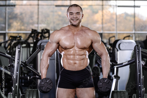 Brutal strong bodybuilder athletic men pumping up muscles with dumbbells