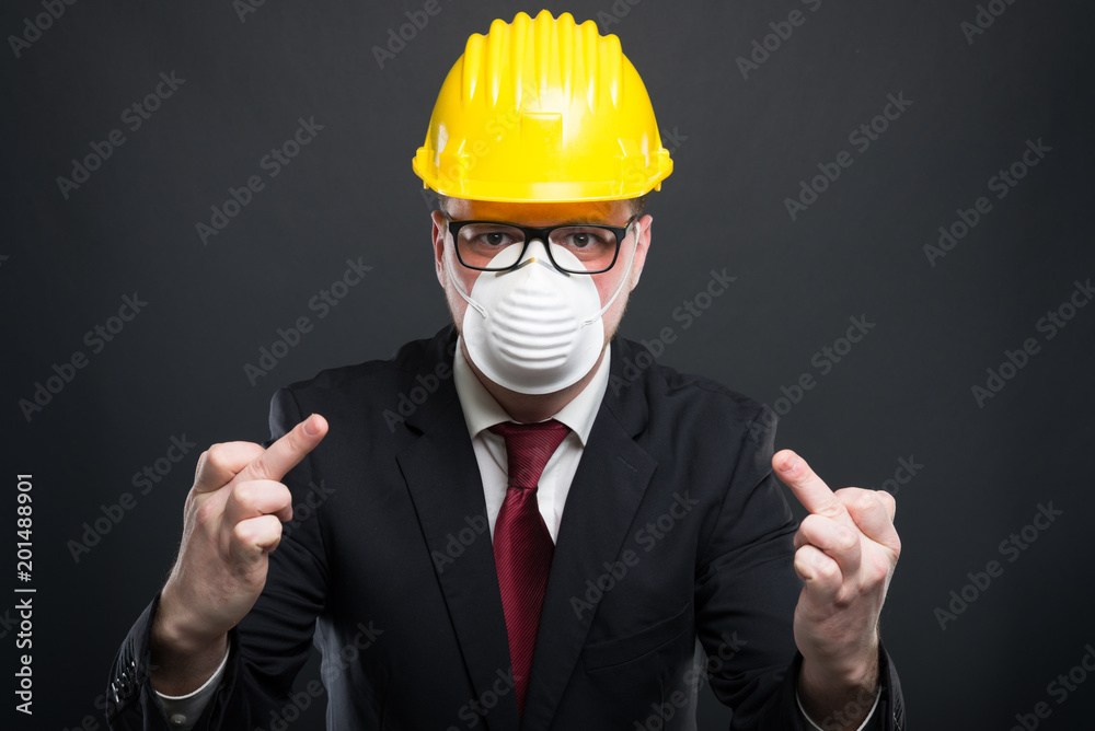 Business man wearing hardhat and mask showing double obscene gesture. Business man wearing hardhat and mask showing double obscene gesture.