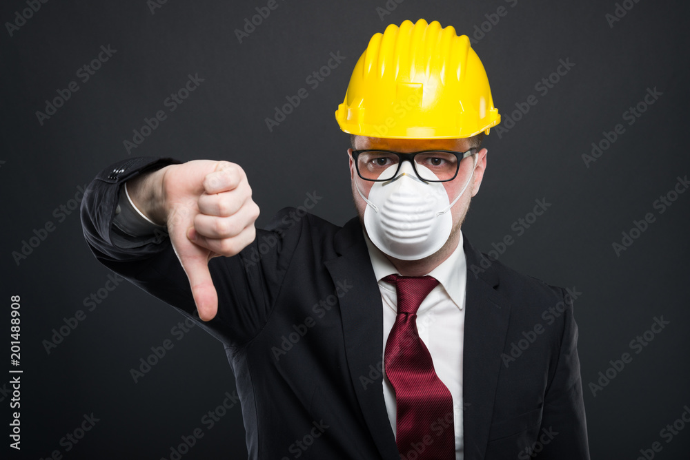 Business man wearing hardhat and mask showing dislike. Business man wearing hardhat and mask showing dislike.