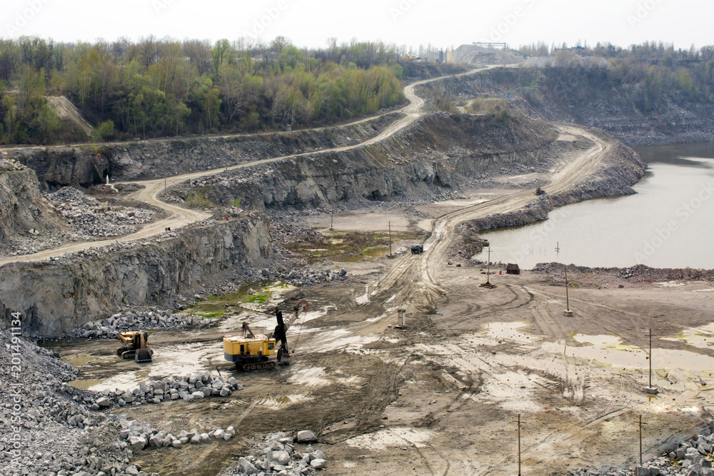 Excavator works mining of granite in a quarry. heavy machinery Excavator works mining of granite in a quarry. heavy machinery