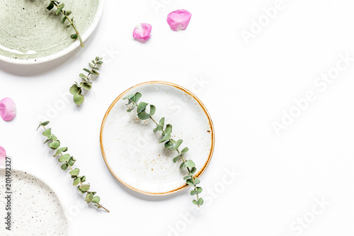 rose, eucalyptus and plates in spring design white background to