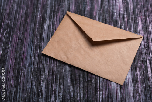 Envelope of Kraft paper. Love letter envelope. Wooden background. Social network.