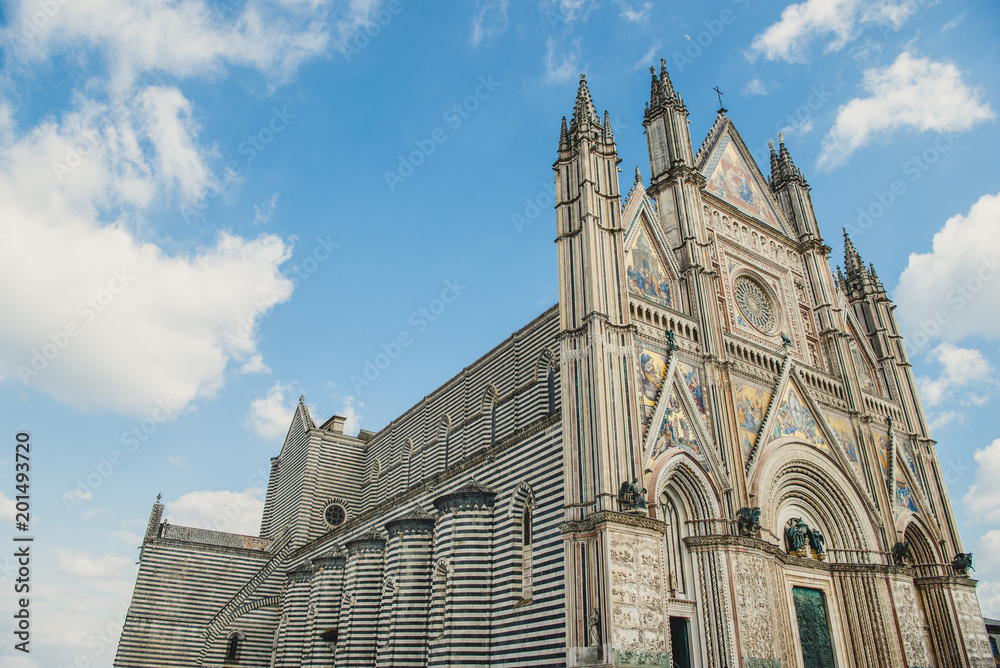 low angle view of ancient Orvieto Cathedral against blue sky in Orvieto, Rome suburb, Italy