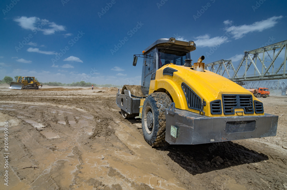 Roller on earthworks on the background of construction