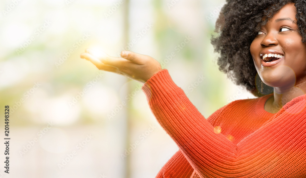 Beautiful african woman holding something in his empty hand, outdoor Beautiful african woman holding something in his empty hand, outdoor