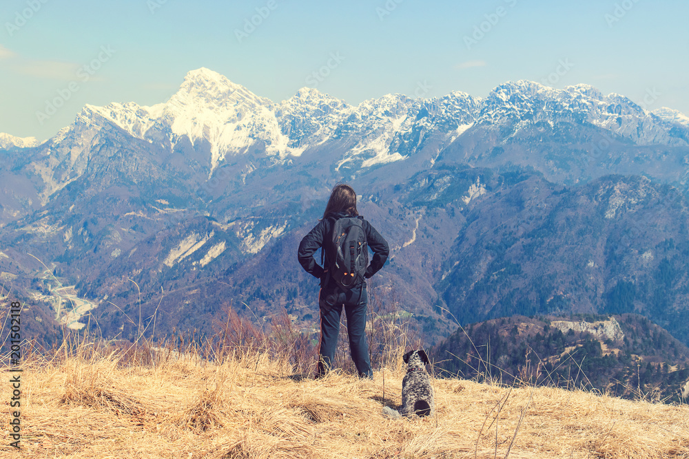 woman with dog enjoying the mountains. Sportive Girl Exploring The Nature

