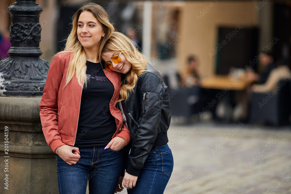 Two girls on the city street and talk to each other