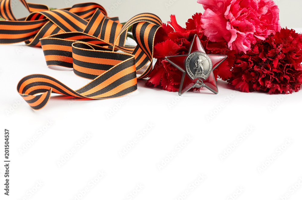 Concept background of May 9 russian holiday Victory Day. Red carnations, St. George's ribbon and order of the Red Star