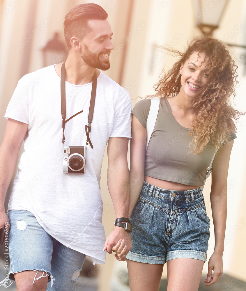 A loving couple of tourists look at each other and walking A loving couple of tourists look at each other and walking