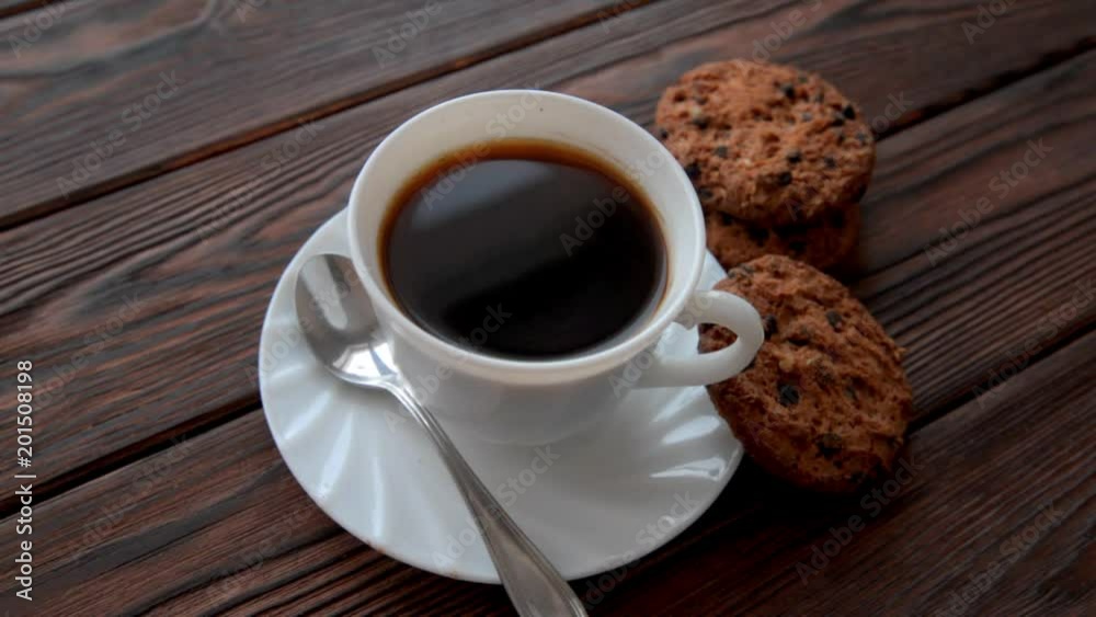 A cup of hot coffee stands on a wooden table A cup of hot coffee stands on a wooden table