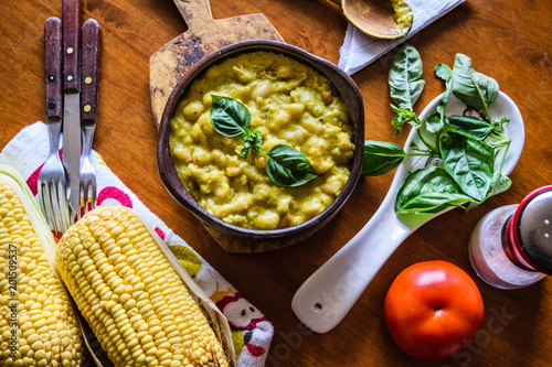 Classical Chilean food white beans in corn sauce in a clay bowl closeup. Porotos con mazamorra in spanish. photo