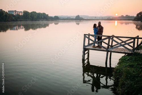 Walk the morning of a guy and a girl. Love story on the bridge. Young people by the lake.