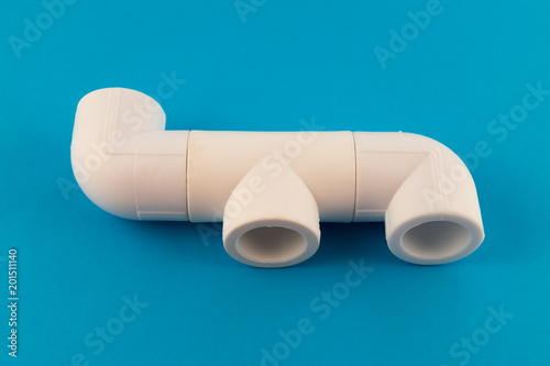 Fittings for the installation of water pipes - tee and two corners of white plastic for soldering the water supply system from PVC pipes.
