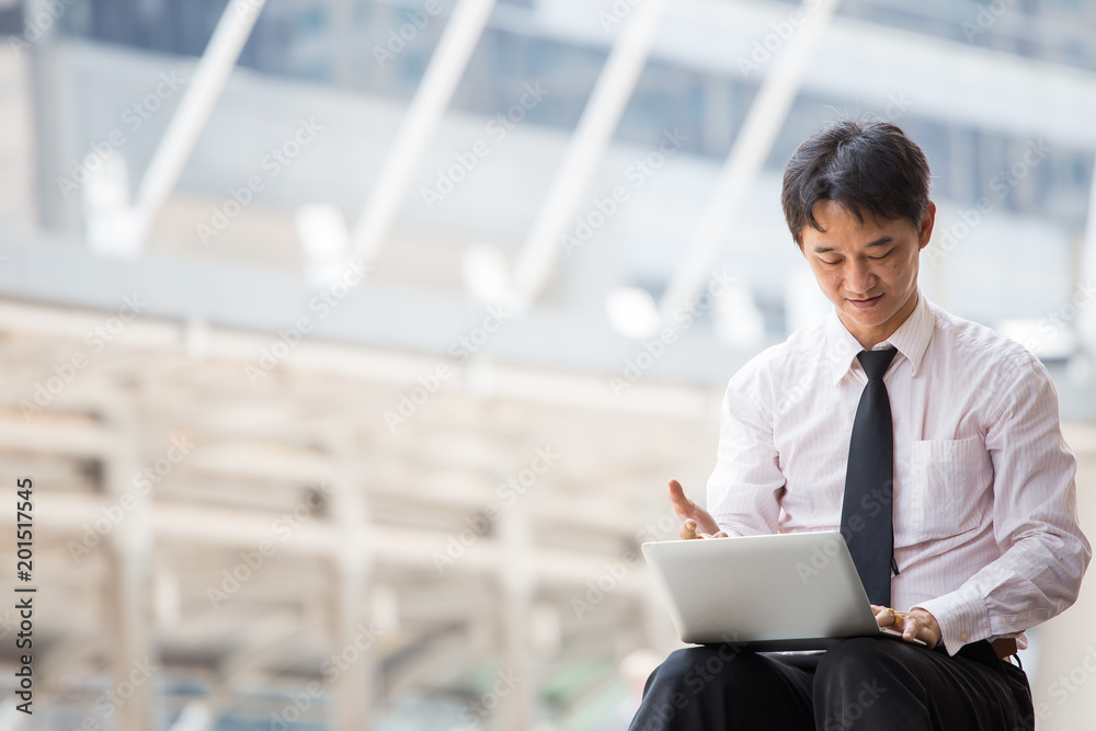 Fototapeta premium Asian businessman working on train station