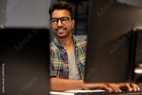 deadline, technology and people concept - close up of creative man in glasses working at night office and thinking photo