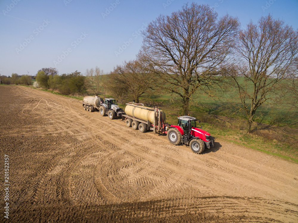 Obraz premium aerial view of a tractor with a trailer with liquid fertilizer