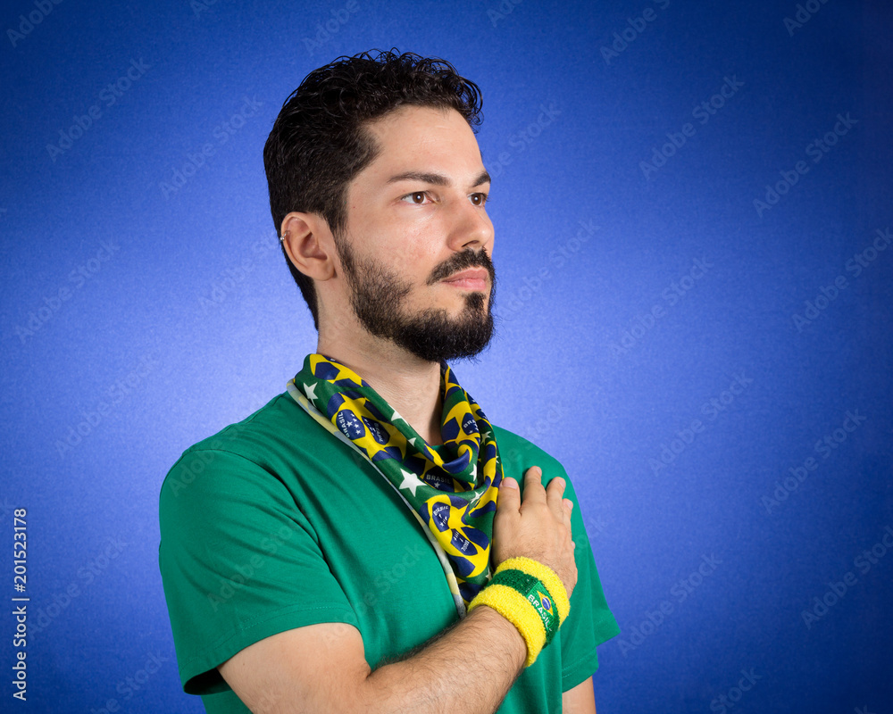 Brazilian supporter of National Team of football is listening to