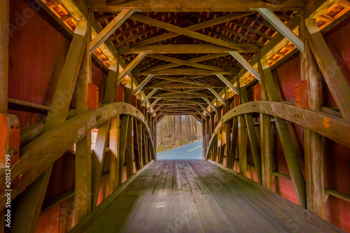 Fotografia, Obraz Indoor view of details of red covered bridge inside of the forest in Lancaster