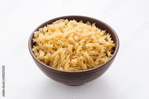 Spiral pasta in bowl on white background