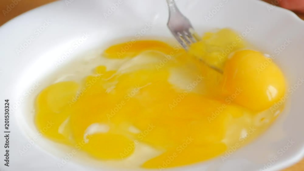 whips the eggs in a bowl with a whisk. Whisking the eggs. whips the eggs in a bowl with a whisk. Whisking the eggs.