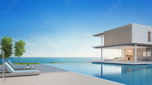Luxury beach house with sea view swimming pool and terrace in modern design, Lounge chairs on wooden floor deck at vacation home or hotel - 3d illustration of contemporary holiday villa exterior © terng99