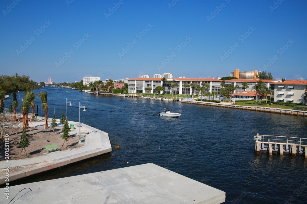 Boat Approaches the Intracoastal Waterway Bridge Just North of Hillsboro Blvd. in a Bright Sunny Afternoon with the Boca Hotel and Resort in the Background