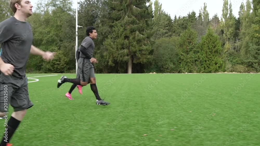 Male soccer players jogging across soccer pitch. Male soccer players jogging across soccer pitch.
