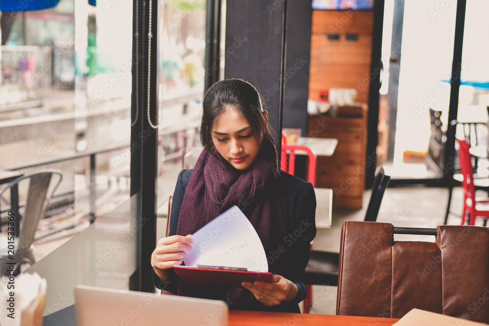 Fototapeta premium Business Concept.Young Asian businesswoman is working happily.Young businesswoman working in a cafe.Young businesswoman is relaxation in a coffee shop.