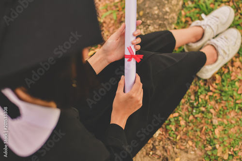 Graduation Concept. Graduated students on graduation day. Asian students are smiling happily on the graduation day. Students wear graduation gowns in the garden