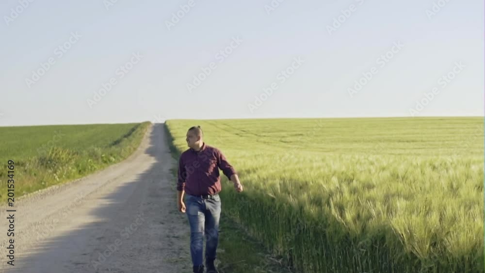 Man walking alongside endless fields - slow motion Man walking alongside endless fields - slow motion