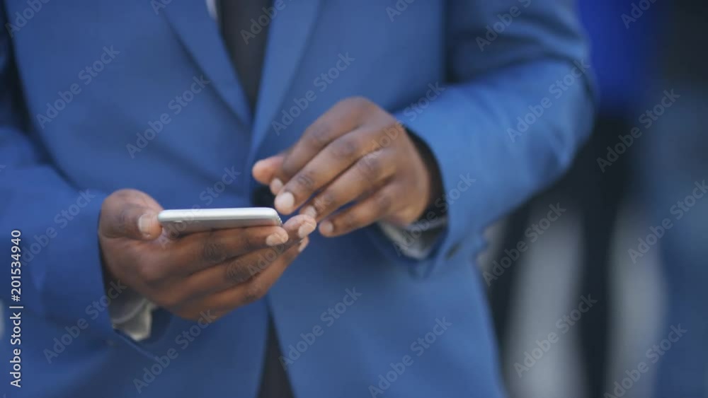 Portrait of handsome black business man using his phone and then looking to camera Portrait of handsome black business man using his phone and then looking to camera