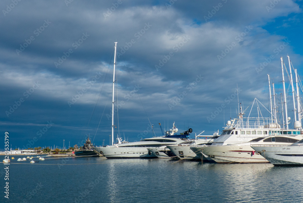 Nice view of the luxury boats in the port of Valencia with the blue sky and clouds at sunset