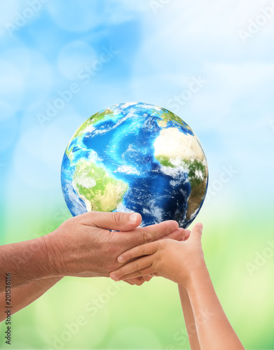 The man holding planet Earth with baby over nature background. 