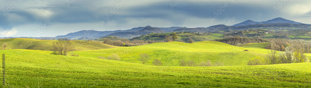 panorama landscape with green fields under clouds in Tuscany in Italy