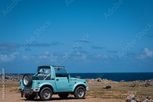 Old exotic jeep parked near ocean