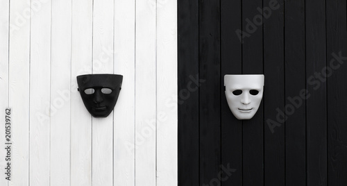 black and white theatrical masks on a black and white wooden table