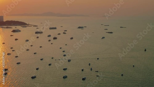 Up view of boats and ship in Pattaya bay in sunbeams during picturasque sunset photo