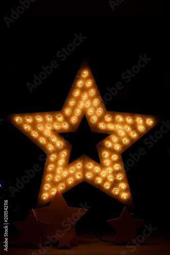 Decorative star with lamps on a background of wall. Modern grung