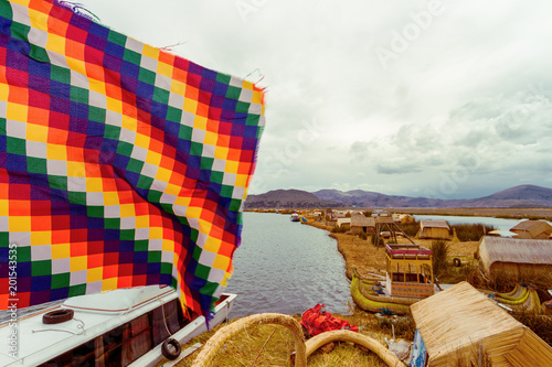 Floating Uros Island on Lake Titicaca seen from a watchtower with Wiphala Flag in the foreground photo