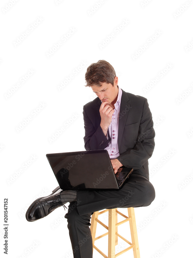 Puzzled young business man sitting and wondering Puzzled young business man sitting and wondering
