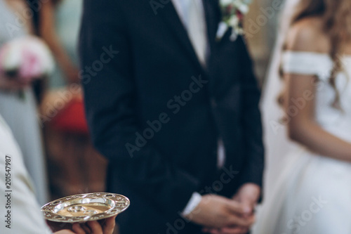 wedding rings on golden plate in church. holy matrimony. wedding ceremony concept