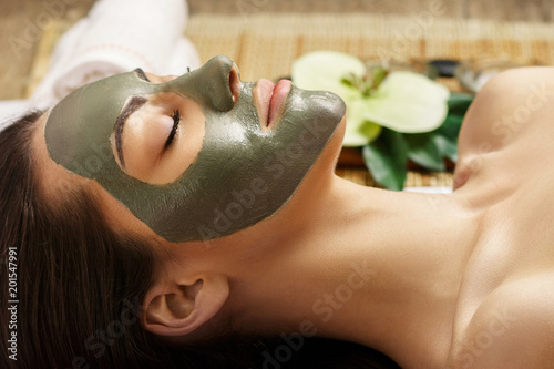 Spa Clay Mask. Woman with clay facial mask   in beauty spa. Skin photo