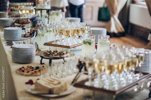 stylish champagne glasses and food  appetizers on table at wedding reception. luxury catering at celebrations. serving food and drinks at events concept photo